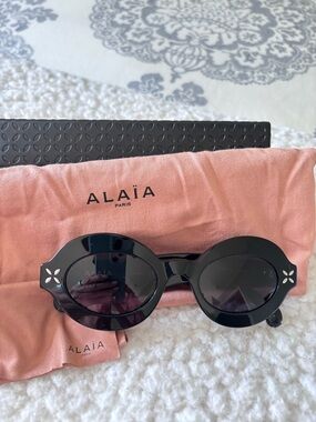 Alaïa Black Round Sunglasses with Floral Cutout Temples